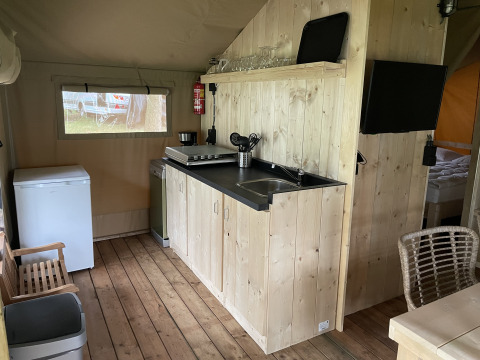 Træbeklædt tekøkken i et safaritelt ved Summer Lodge, Beerze Bulten, Nederlandene, med moderne faciliteter.