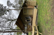 Tienda safari Summer Lodge en Beerze Bulten, Países Bajos, con terraza de madera y mesa de picnic exterior.