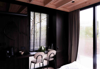 Interior moderno de la Nokken NKN-18 Cabin en Wilsumer Berge, Alemania, con escritorio acogedor y ventana grande.