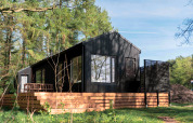 Lodge en bois noir, Koya Tiny Cabin, avec terrasse, située dans la forêt à Wilsumer Berge, Allemagne.