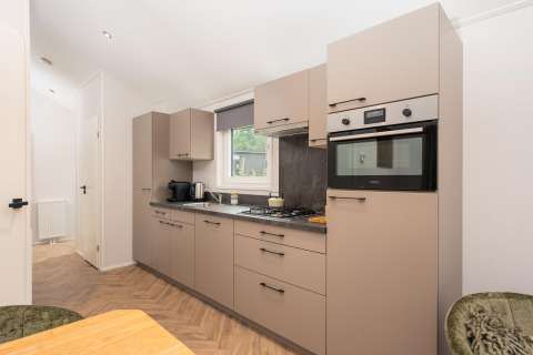 Moderne Küche in der Velthorst Comfort Lodge im Veluwepark de Bosgraaf, Niederlande, mit eleganten Schränken.