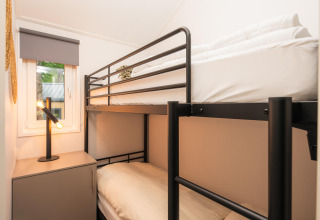 Letto a castello moderno vicino alla finestra e lampada da tavolo al Velthorst Comfort, Veluwepark de Bosgraaf, Paesi Bassi.