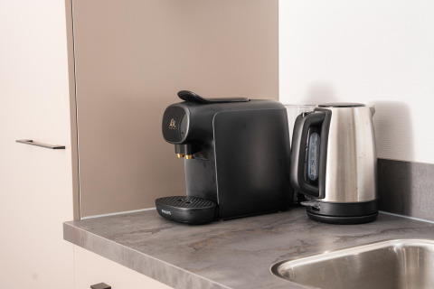 Macchina da caffè e bollitore elettrico sul piano cucina al lodge Velthorst Comfort, Veluwepark de Bosgraaf, Paesi Bassi.
