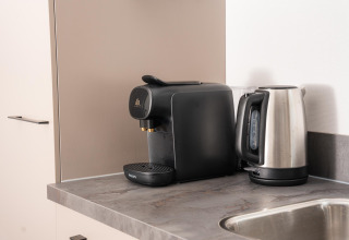 Macchina da caffè e bollitore elettrico sul piano cucina al lodge Velthorst Comfort, Veluwepark de Bosgraaf, Paesi Bassi.