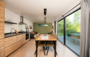 Modernes Ess- und Wohnzimmer in einem Comfort Chalet im Veluwepark de Bosgraaf, Niederlande, mit großen Fenstern.