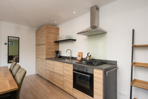 Cocina moderna de madera en Comfort Chalet del Veluwepark de Bosgraaf, Países Bajos, con mesa de comedor.