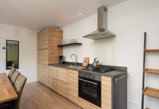 Cocina moderna de madera en Comfort Chalet del Veluwepark de Bosgraaf, Países Bajos, con mesa de comedor.