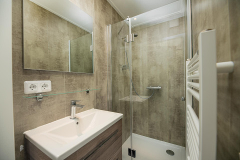 Baño moderno en Comfort Chalet de Veluwepark de Bosgraaf, Países Bajos, con ducha, lavabo y espejo.