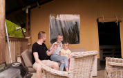 Gezin ontspant op het terras van een safaritent bij Wilsumer Berge in Duitsland op een zonnige dag.