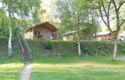 Tienda safari en Petite Suisse, Bélgica, rodeada de naturaleza, árboles y espacio de césped y picnic.
