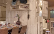Interior de la tienda safari Dreamer en Petite Suisse, Bélgica, con decoración de madera y comedor acogedor.
