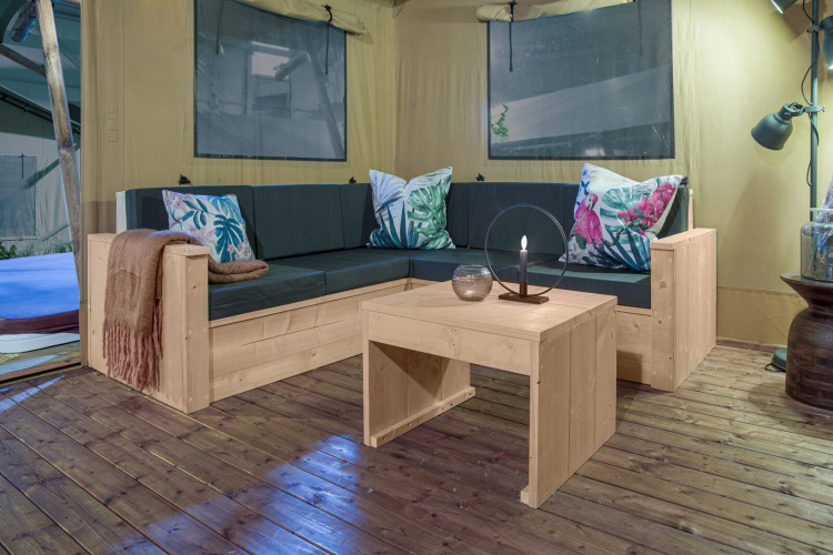 Gemütliche Sitzecke im Safari-Zelt Dreamer, Petite Suisse, Belgien, mit stilvollen Holzmöbeln.