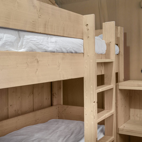 Light wood bunk bed with white bedding inside the Dreamer safari tent at Petite Suisse, Belgium.