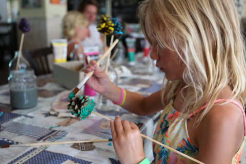 Una bambina dipinge una pigna durante un laboratorio creativo all'Holiday Park Bonte Vlucht a Utrecht, Paesi Bassi.