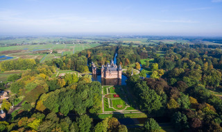 Luchtfoto van een kasteel bij Doorn in Utrecht, Nederland, omgeven door bossen, tuinen en weilanden.