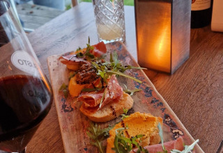 Gezellige tapasplank met bruschetta, wijn en sfeerverlichting in Marina Parcs Lelystad, Flevoland.