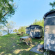 Små hytter ved Marina Parcs Almere, Tiny Wagon, omgivet af grønne træer og picnicborde i Holland.