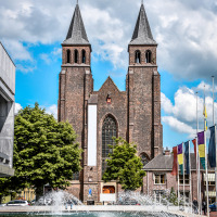 Historische kerk met dubbele torens en fontein, gefotografeerd nabij Lathum, Gelderland, Nederland.