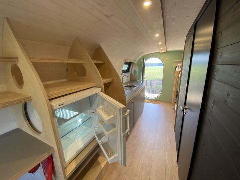 Innenansicht eines modernen Ferienhauses mit Küchenzeile und offenem Kühlschrank im Holiday Park 't Rheezerwold.