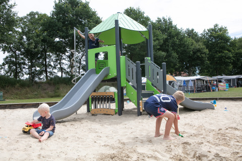 Bambini che giocano nella sabbiera e sullo scivolo al parco giochi del Holiday Park 't Rheezerwold, Overijssel, Paesi Bassi.