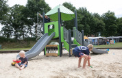 Bambini che giocano nella sabbiera e sullo scivolo al parco giochi del Holiday Park 't Rheezerwold, Overijssel, Paesi Bassi.