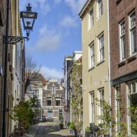Malerische Altstadtstraße mit historischen Gebäuden, Fahrrädern und Blumenschmuck an einem sonnigen Tag.