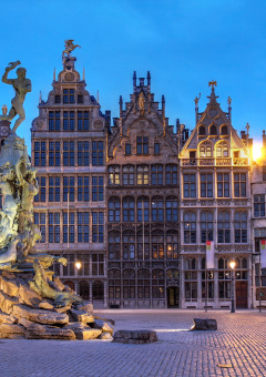 Avondzicht op Grote Markt in Antwerpen met Brabo-fontein en verlichte historische gildehuizen.
