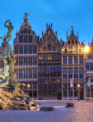 Avondzicht op Grote Markt in Antwerpen met Brabo-fontein en verlichte historische gildehuizen.