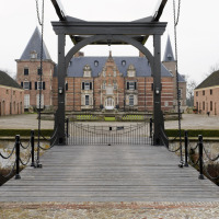 Foto de un puente levadizo y un castillo cerca de Enter, Overijssel, Países Bajos, rodeados de edificios.