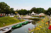 Flores silvestres y botes junto a un canal en Holiday Park Mölke, Overijssel, Países Bajos en verano.