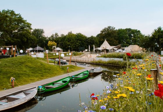 Fiori colorati e barche vicino al canale al Holiday Park Mölke, Overijssel, Paesi Bassi in estate.