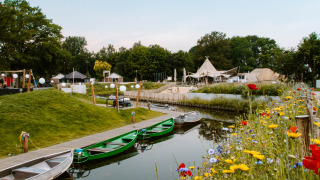 Wilde bloemen en boten aan een rustig kanaal bij Holiday Park Mölke, Overijssel, Nederland in de zomer.