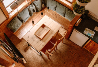 Gemütlicher Holz-Innenraum mit Esstisch und Eckbank im Holiday Park Mölke, Overijssel, Niederlande.