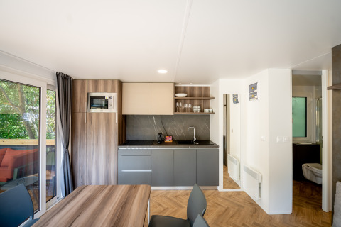 Modern holiday park kitchen at Urban-Gardens in East Flanders, Belgium, with dining area and terrace view.