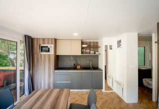 Moderne keuken bij Urban-Gardens vakantiepark in Oost-Vlaanderen, België, met eetgedeelte en terraszicht.