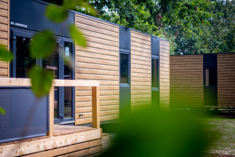 Moderni lodge di legno presso Urban-Gardens, parco vacanze in Fiandre Orientali, Belgio, immersi nel verde.