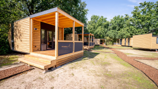 Moderne houten huisjes in Urban-Gardens vakantiepark in Oost-Vlaanderen, België, tussen het groen.