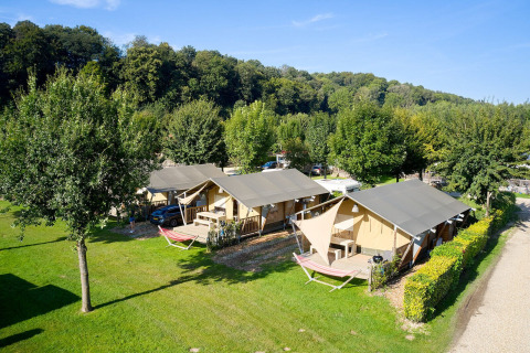 Tiendas tipo safari Villatent Nomad en Camping 't Geuldal, Países Bajos, rodeadas de naturaleza verde.