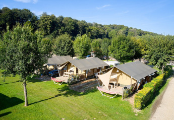 Tiendas tipo safari Villatent Nomad en Camping 't Geuldal, Países Bajos, rodeadas de naturaleza verde.