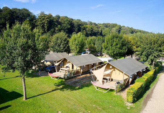 Tiendas tipo safari Villatent Nomad en Camping 't Geuldal, Países Bajos, rodeadas de naturaleza verde.