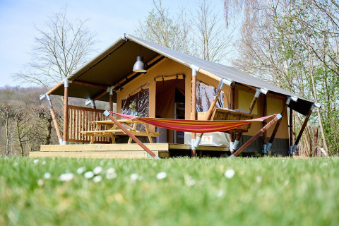 Tienda safari llamada Villatent Compact con hamaca en Camping 't Geuldal, Países Bajos, en primavera.