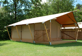 Tenda safari presso Baalse Hei in Belgio con struttura in legno e veranda coperta immersa nel verde.