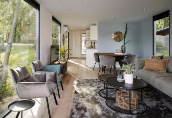 Intérieur moderne du lodge Water Cube, grandes fenêtres, décoration élégante et vue sur le jardin.