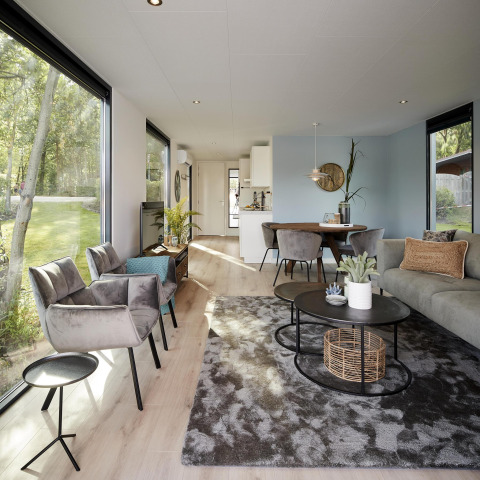 Modern interieur van de Water Cube lodge met grote ramen, stijlvolle meubels en uitzicht op tuin.