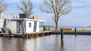 Casa flotante Aqua Dolce en Welcome In - Friesland, Países Bajos, atracada junto al agua con terraza.