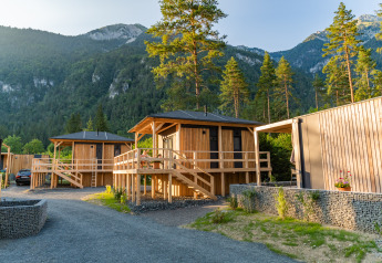 Houten chalets bij Edelweiss Lodge in de bergen, omringd door bosrijke natuur en prachtig uitzicht.