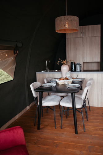 Comedor moderno en Waterlodge, Recreatiepark De Achterste Hoef, Países Bajos, con mesa y cocina.