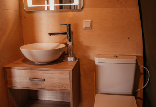 Baño moderno en la Waterlodge de Recreatiepark De Achterste Hoef, Países Bajos, con lavabo, wc y espejo.