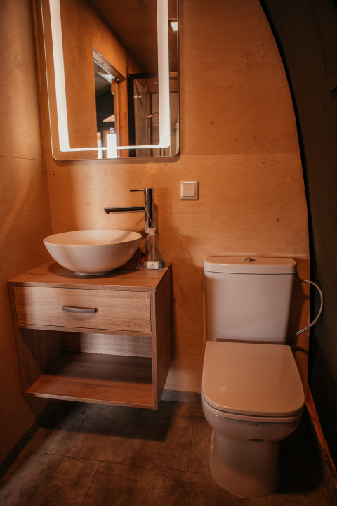 Baño moderno en la Waterlodge de Recreatiepark De Achterste Hoef, Países Bajos, con lavabo, wc y espejo.