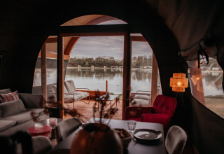 Intérieur cosy de la Waterlodge avec vue sur le lac à travers de grandes fenêtres à De Achterste Hoef, Pays-Bas.